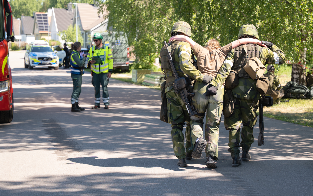 En grupp soldater som g&aring;r l&auml;ngs en gata.