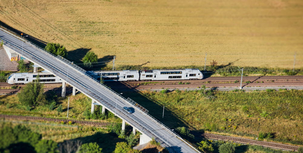 Ett tåg passerar under en landsväg.