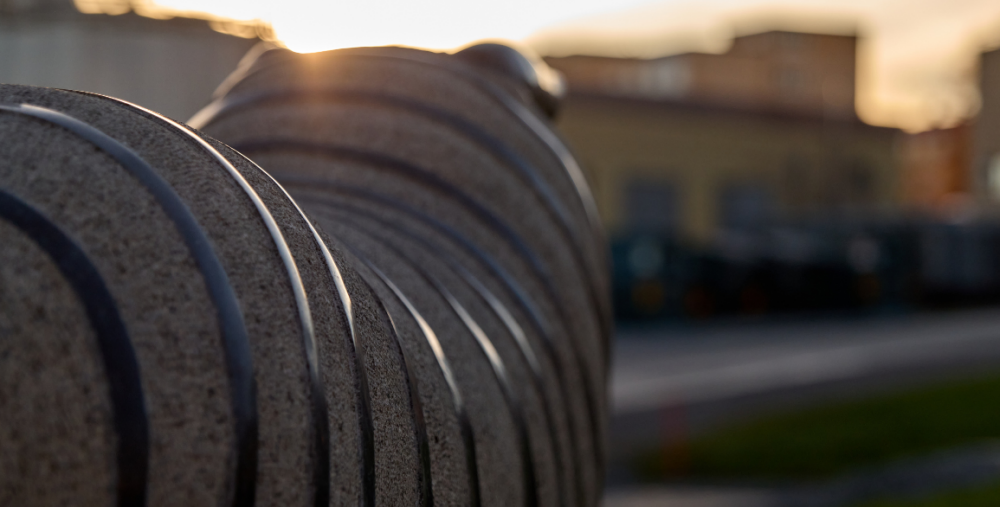Granitskulptur i form av ett får i stadsmiljö, fotograferad i motljus.