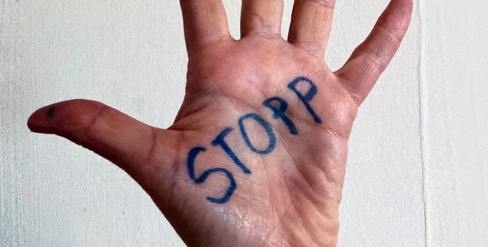 Uppräckt hand med texten "Stopp"