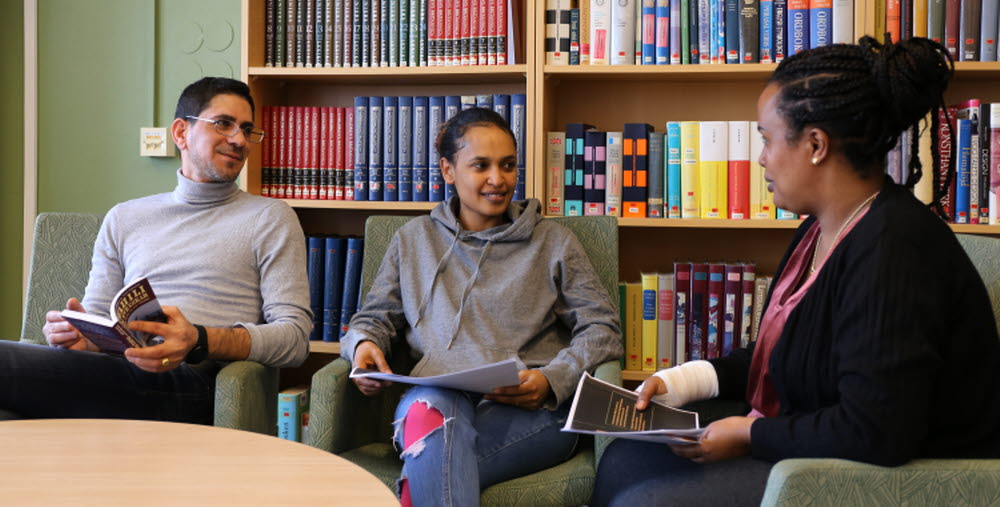 Kursdeltagare sitter i fåtöljer och läser böcker